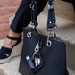 A black vegan leather Keychain Bracelet on bag, with lip balm holder and card holder